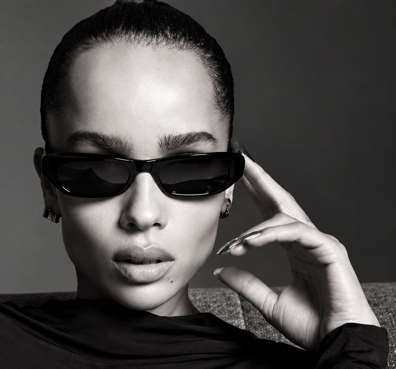 Femme en lunettes de soleil noires, portrait en noir et blanc.