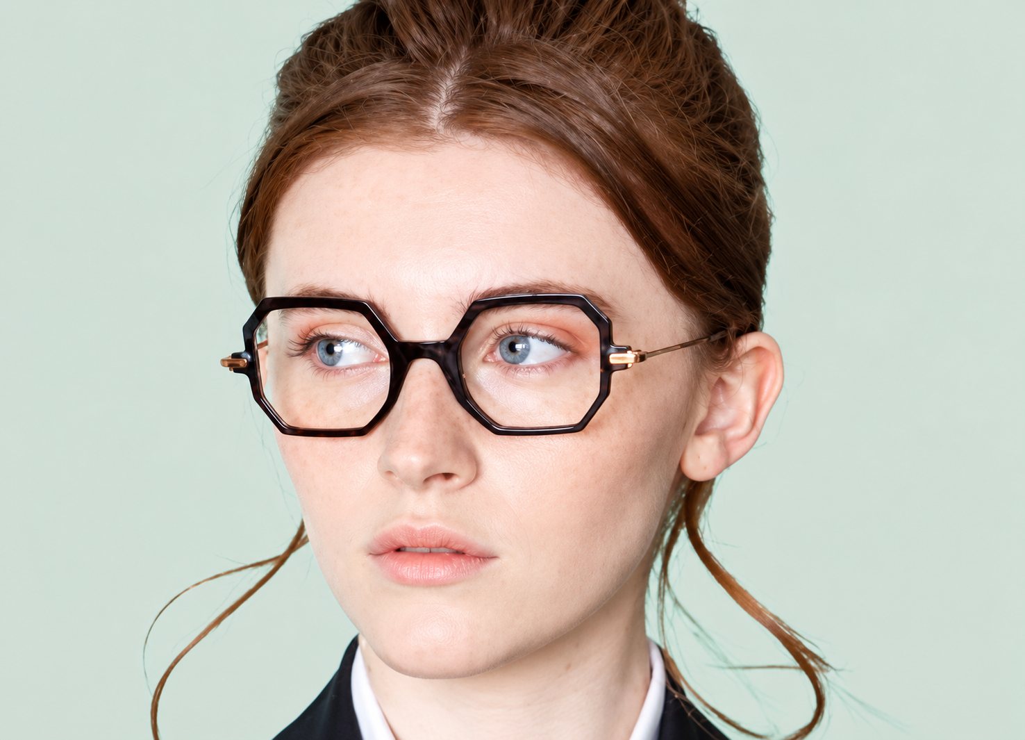 Jeune femme portant des lunettes noires aux formes géométriques.
